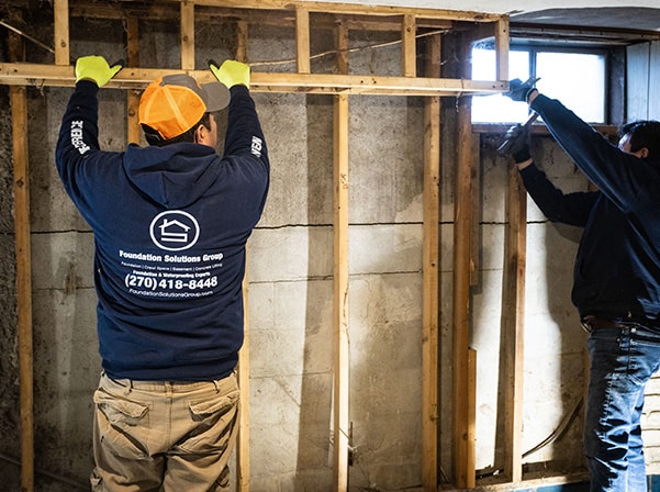 men putting up wall studs
