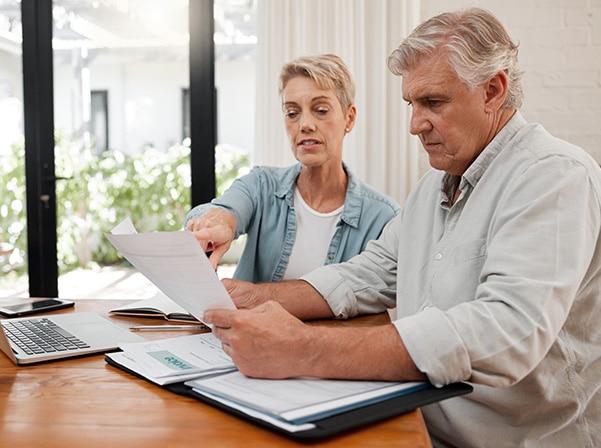 couple looking at paper sitting at table