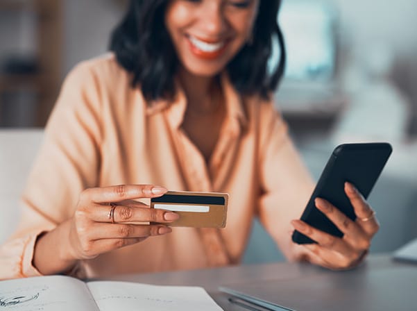 woman holding credit card and phone