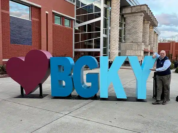 man standing next to BGKY sign